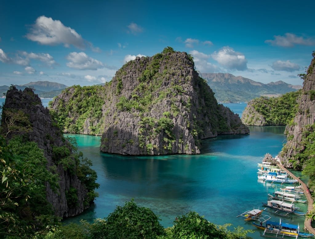 Stunning view of Coron Island's turquoise waters with rock formations and boats.